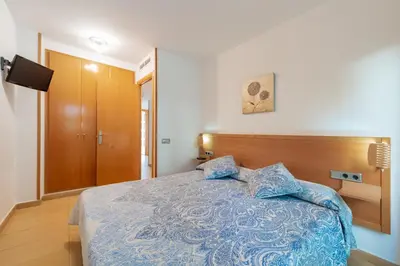 a bedroom with a bed with a blue comforter at InSitges Sant Sebastia's Beach in Sitges