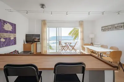 a dining room with a table and a view of the ocean at InSitges Sant Sebastia's Beach in Sitges