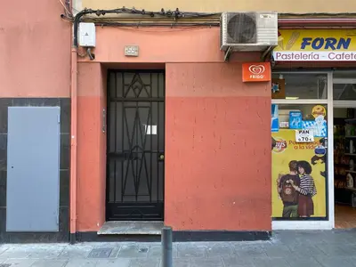 a red building with a door on a street at Rafael Apartment by Olala Homes in Hospitalet de Llobregat