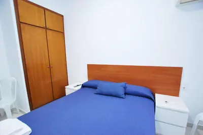 a bedroom with a blue bed with a wooden headboard at Hotel Tres Leones in Vilassar de Mar