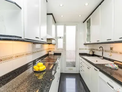 a kitchen with white cabinets and a bowl of fruit on the counter at Apartment Sants-Les Corts Galileu by Interhome in Barcelona