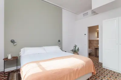 a white bedroom with a bed with an orange blanket at Flateli Pelayo H5 in Barcelona