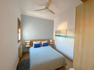 a bedroom with a bed and a ceiling fan at Sunny Apt Barcelona 22 in Barcelona