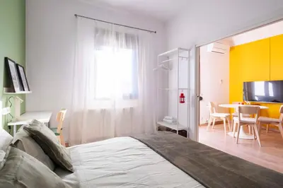 a bedroom with a bed and a table with chairs at Sunny Apt Barcelona 22 in Barcelona