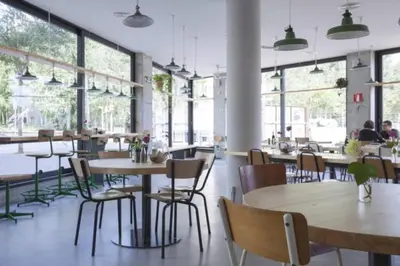 a restaurant with tables and chairs and windows at Sunny Apt Barcelona 22 in Barcelona