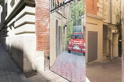 a reflection of a red car in a window at Romantic In Trendy Gracia in Barcelona