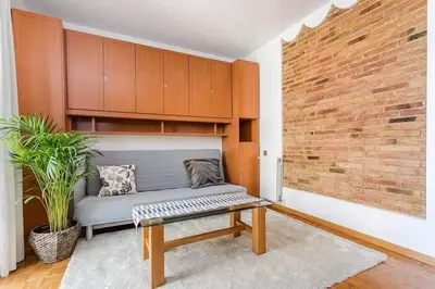 a living room with a bench and a brick wall at Vive Como Un Barcelons in Barcelona