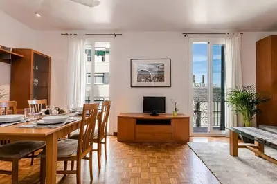 a dining room with a table with chairs and a television at Vive Como Un Barcelons in Barcelona