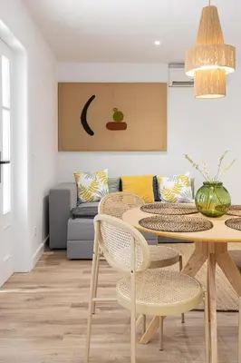 a living room with a table and chairs and a couch at Walk To Las Ramblas Sun-filled&cozy in Barcelona