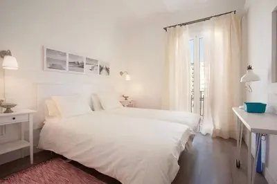 a white bedroom with a white bed and a window at Apt In 22 Close To The Beach in Barcelona