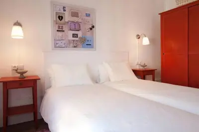 a bedroom with a white bed with two nightstands and two lamps at Apt In 22 Close To The Beach in Barcelona