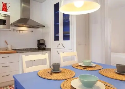 a kitchen with a blue table with four bowls on it at Apt In 22 Close To The Beach in Barcelona