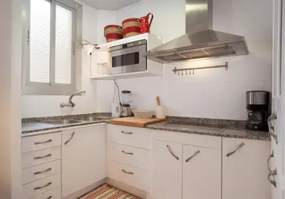 a white kitchen with a sink and a microwave at Apt In 22 Close To The Beach in Barcelona