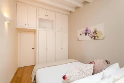 a bedroom with a white bed and white cabinets at Historical Apartment With Awesome Rooftop in Barcelona