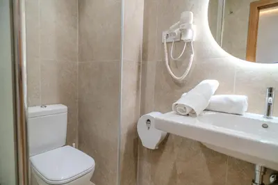 a bathroom with a toilet and a sink and a mirror at HolidaysBCN Rooms in Barcelona