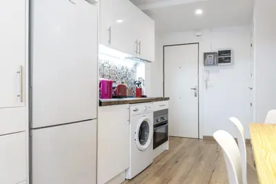 a kitchen with white cabinets and a washer and dryer at Besos Beach Gem 1 By MyRentalHost in Sant Adria de Besos