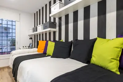 a bedroom with a large bed with colorful pillows at Besos Beach Gem 1 By MyRentalHost in Sant Adria de Besos