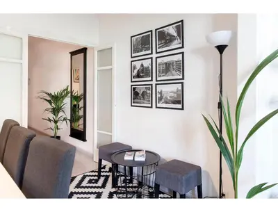 a living room with a table and chairs and pictures on the wall at CENTRAL STYLISH EIXAMPLE - Casa Antonio By MyRentalHost in Barcelona