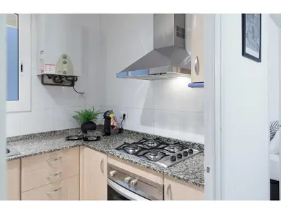 a kitchen with a stove and a counter top at CENTRAL STYLISH EIXAMPLE - Casa Antonio By MyRentalHost in Barcelona