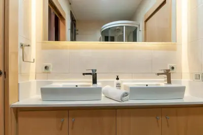a bathroom with two sinks and a mirror at Casa PILAR Central By MyRentalHost in Barcelona