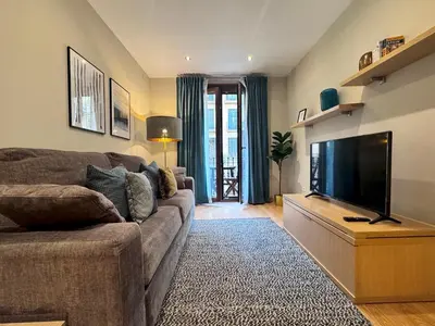 a living room with a couch and a flat screen tv at Casa PILAR Central By MyRentalHost in Barcelona