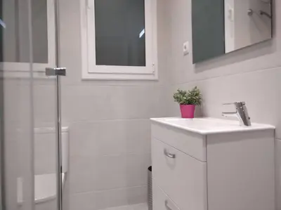 a white bathroom with a sink and a shower at Sagrada Familia ART Apt By MyRentalHost in Barcelona