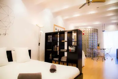 a bedroom with a bed and a book shelf at Studio Gracia By MyRentalHost in Barcelona