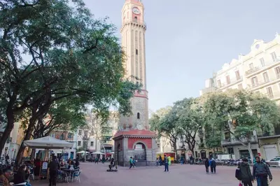 a clock tower in a city with a crowd of people at Studio Gracia By MyRentalHost in Barcelona