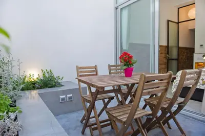 a wooden table and chairs on a patio at Architects Home By MyRentalHost in Barcelona