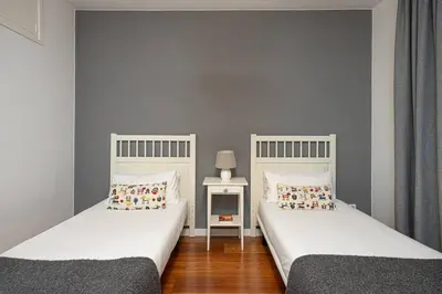 two twin beds in a room with a side table at Live Like A Local In Bcn in Barcelona