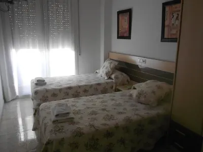 a bedroom with two beds and a mirror at Hostal Ca La Irene in San Vicente de Castellet