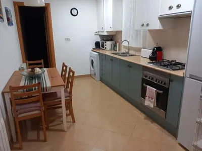 a kitchen with a table and a stove top oven at Cozy Apartment Near The Beach in Barcelona