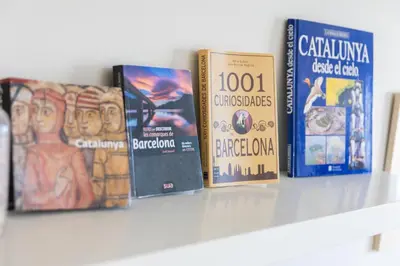 a row of books sitting on a shelf at Housalia Sagrada Familia Views in Barcelona