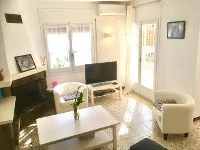 a living room with white furniture and a flat screen tv at CASA DEL BOSQUE CON PISCINA EN SITGES in Sant Pere de Ribes