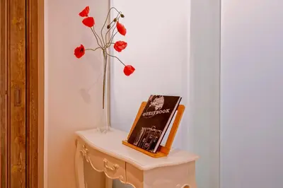 a table with a vase and a book and flowers at Gran casa al lado de la playa y Barcelona Centro in Badalona