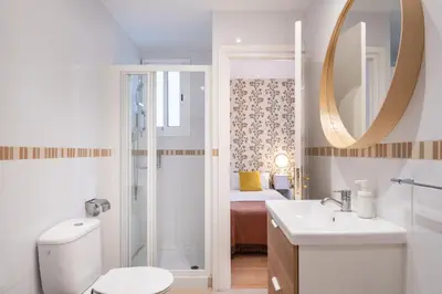 a bathroom with a toilet and a sink and a mirror at Penthouse Apartment with Terrace in Barcelona City Center in Barcelona