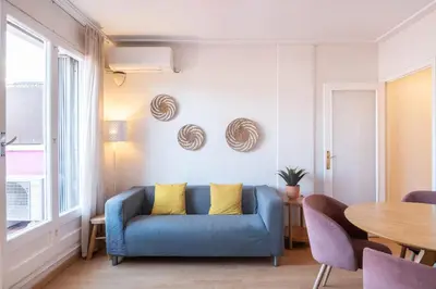 a living room with a blue couch and a table at Penthouse Apartment with Terrace in Barcelona City Center in Barcelona