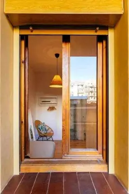 a glass door to a balcony with a chair outside at Cozy & Central Apartment in Barcelona