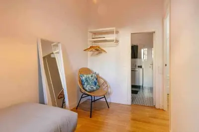 a room with a chair in a room with a kitchen at Cozy & Central Apartment in Barcelona