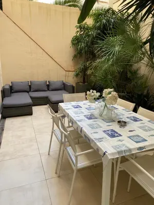 a table and chairs in a patio with a couch at Vive la playa y la noche de Sitges aquí in Sitges