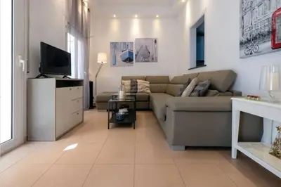 a living room with a couch and a tv at Vive la playa y la noche de Sitges aquí in Sitges