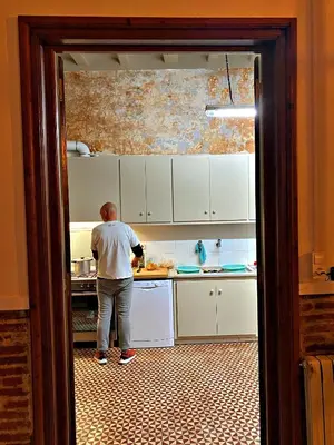 an open door with two windows with white curtains at Can Martí in Vallgorguina
