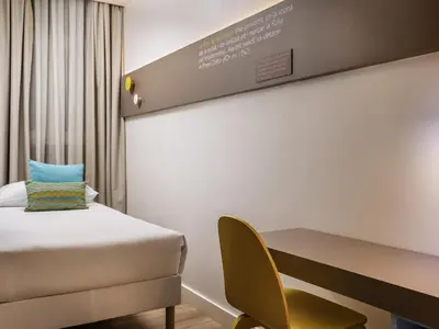 a bedroom with a bed and a desk and a chair at ibis Styles Barcelona Centre in Barcelona