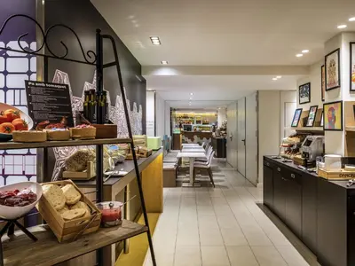 a restaurant with a counter with bar stools at ibis Styles Barcelona Centre in Barcelona
