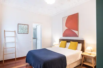 a bedroom with a bed and a painting on the wall at Modernist apartment in the best location, Eixample in Barcelona