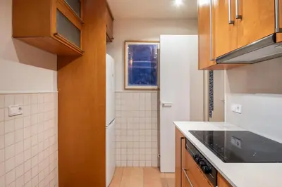 a kitchen with brown cabinets and a white tiled wall at Spacious & Comfortable Apartment in Barcelona City Center in Barcelona