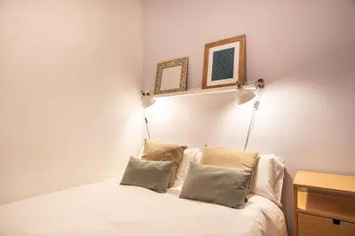 a bedroom with a white bed with two pillows at Spacious & Sunny Apartment with Terrace in the city center in Barcelona
