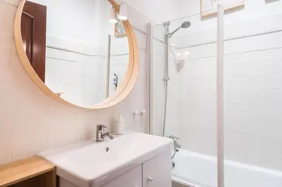 a white bathroom with a sink and a mirror at Spacious & Sunny Apartment with Terrace in the city center in Barcelona