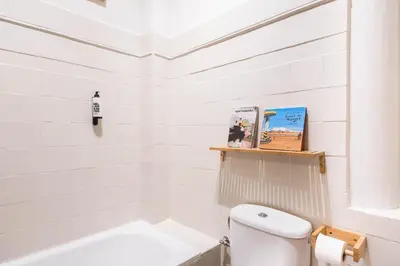 a white bathroom with a toilet and a sink at Spacious & Sunny Apartment with Terrace in the city center in Barcelona