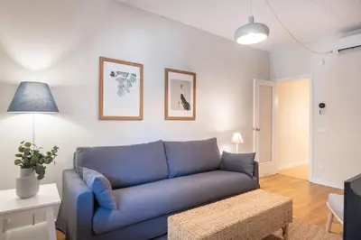 a blue couch sitting in a living room at Comfortable 3-Bedroom Apartment next to Sagrada Familia, Barcelona in Barcelona